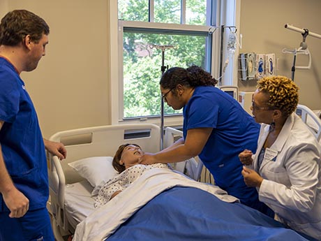 Student and professor working in Nursing Sim lab