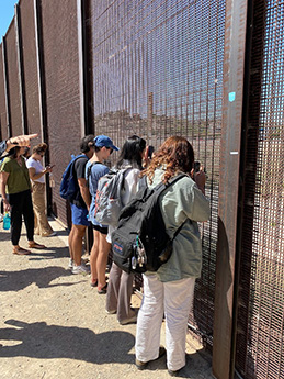 Students look through the border wall