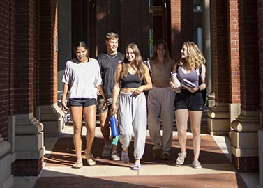 Student group walking through library arches