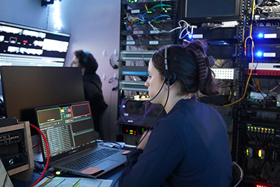 Student operating computers in broadcast booth